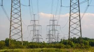 High-voltage transmission towers and power lines crossing a field